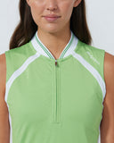 Woman wearing a green sleeveless top with a white zipper on a plain background