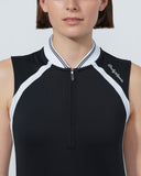 Woman wearing a black and white sleeveless top with a brand logo on a light gray background