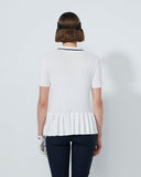 Woman wearing a white polo shirt with a subtle pattern on a plain background