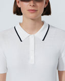 White polo shirt with black trim worn by a person on a plain background