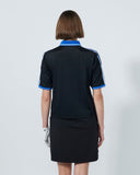 Person wearing a black and blue polo shirt with a skirt on a white background