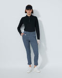 Person wearing a black top and blue patterned pants on a white background