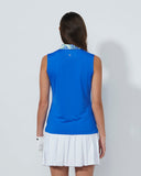 Woman wearing a blue sleeveless top and white skirt on a plain background