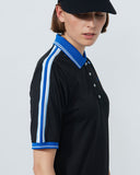 Person wearing a black polo shirt with blue and white stripes on a plain background