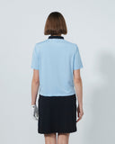 Person wearing a light blue polo shirt and black skirt on a plain background