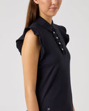 Woman wearing a black dress with ruffled shoulders on a light gray background