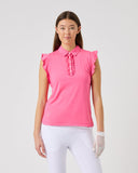 Woman wearing a pink ruffled blouse and white pants on a light gray background