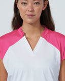 Woman wearing a white and pink top against a plain background