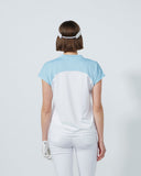 Person wearing a light blue and white shirt with a visor on a plain background