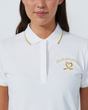 White polo shirt with gold trim and logo on a plain background