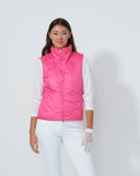 Person wearing a pink puffer vest over a white shirt on a plain background