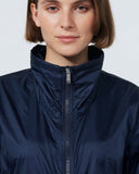 Person wearing a navy blue jacket against a plain background