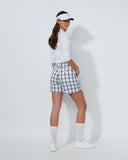 Woman in golf attire with a white shirt, checkered skirt, and visor on a light gray background