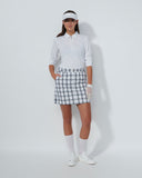 Person wearing a golf outfit with a white shirt, plaid skirt, and visor on a white background