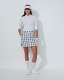Person wearing a golf outfit with a white shirt, plaid skirt, and visor on a white background