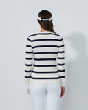 Person wearing a black and white striped sweater and white pants on a plain background