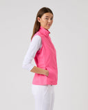 Woman wearing a pink vest over a white shirt on a light gray background