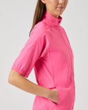 Person wearing a bright pink shirt on a plain background