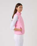 Person wearing a pink vest over a white shirt on a light gray background