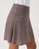 Brown checkered skirt worn with a white shirt on a light gray background