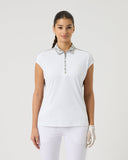 Woman wearing a white sleeveless golf shirt and pants on a light gray background