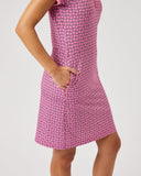Woman wearing a pink dress with a geometric pattern on a white background