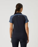 Person wearing a black and blue patterned shirt on a light gray background