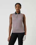 Woman wearing a patterned sleeveless top and black pants on a white background