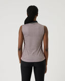 Person wearing a sleeveless patterned top and black pants on a white background