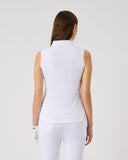 Woman wearing a white sleeveless top and pants on a light gray background