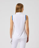 Woman wearing a white sleeveless top and white pants on a light gray background