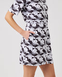 Woman wearing a black and white floral dress on a plain background