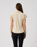 Woman wearing a beige blouse and black pants on a light gray background