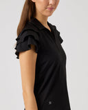 Woman wearing a black top with ruffled sleeves on a plain background