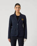 Woman wearing a navy blazer with a logo on a light gray background