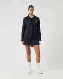 Person wearing a navy blazer and shorts set on a white background