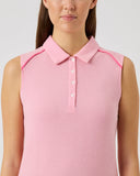 Woman wearing a pink sleeveless dress with a collar against a light gray background