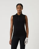 Woman wearing a black sleeveless polo shirt and black pants on a white background