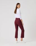 Woman wearing burgundy pants and a white top on a white background
