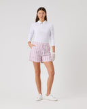 Woman wearing a white shirt and pink checkered shorts on a white background