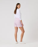 Woman wearing a white top and pink checkered skirt on a white background