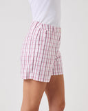 Person wearing red and white checkered shorts on a light gray background