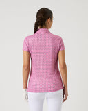 Woman wearing a pink patterned polo shirt on a white background