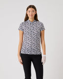 Woman wearing a patterned shirt and black pants on a white background