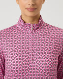 Person wearing a pink patterned shirt against a light gray background