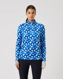 Woman wearing a blue patterned long-sleeve shirt on a gray background