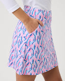 Person wearing a pink and blue patterned skirt on a plain background
