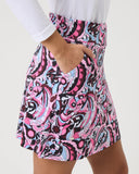 Person wearing a colorful patterned skirt on a plain background