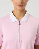 Person wearing a pink polo shirt with a white collar on a light gray background
