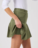 Green skirt worn by a person on a white background